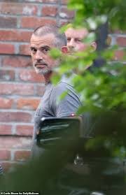 Fotis Dulos looking at the press while walking into a building;