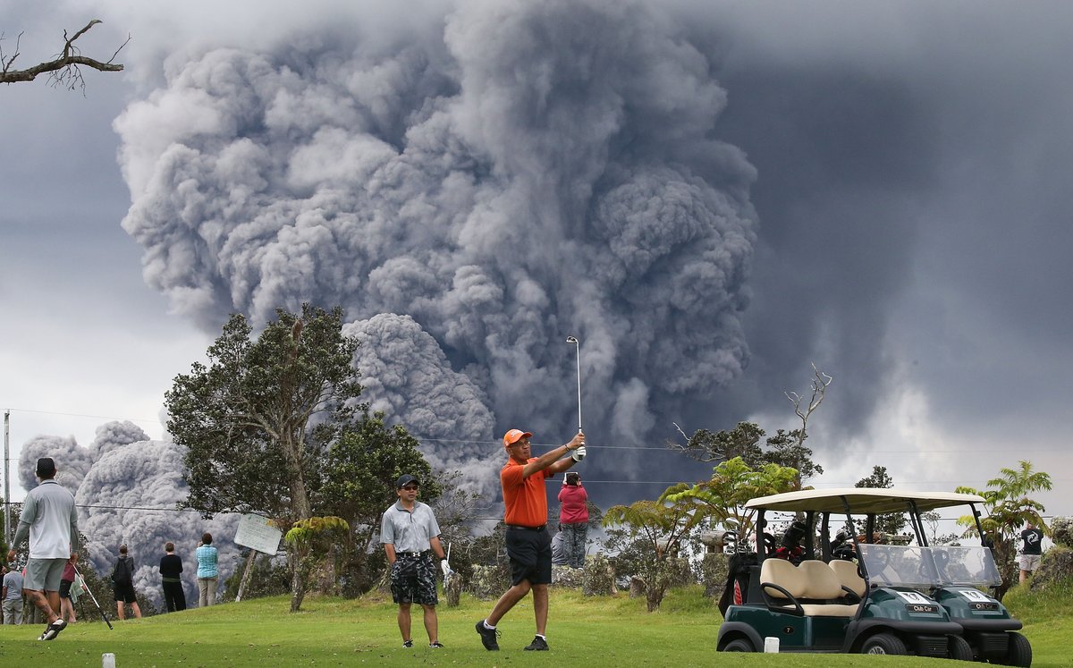 Hawaiian Golfers with volcano ash and smoke in the background;