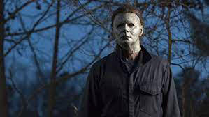 Michael Myers standing outside a wooded area;